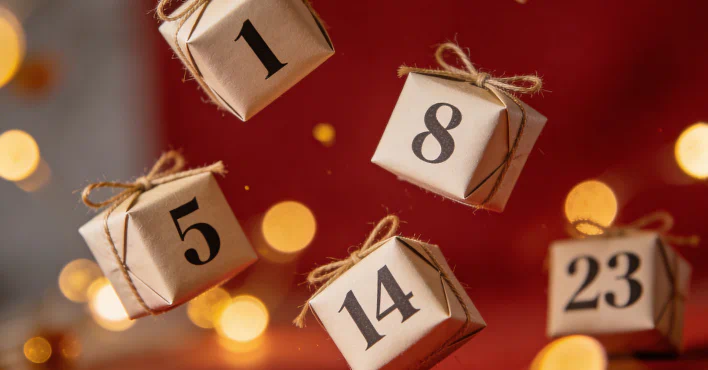 Schwebende Geschenkboxen aus Kraftpapier mit Zahlen wie 1, 5, 8, 14 und 23 als Adventskalender vor rotem Hintergrund und warmen Lichtern.