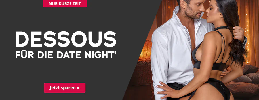 Das Bild zeigt eine Werbeanzeige. Großflächig steht auf dunklem Hintergrund in weißer Schrift: „Nur kurze Zeit – Dessous für die Date Night“. Darunter befindet sich ein rotfarbener Button mit der Aufschrift „Jetzt sparen“. Im Bild ist ein Paar zu sehen: Ein Mann in weißem Hemd und eine Frau in schwarzen Dessous, die eng an ihn gelehnt steht. Der Hintergrund ist warm beleuchtet mit Lichterketten und Vorhängen.