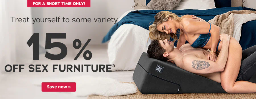 Advertisement with the text: 'For a short time only! Treat yourself to some variety – 15% off sex furniture³'. At the bottom left, a red button with the words 'Save now »'. On the right side of the image, a couple in underwear lies on a black wedge pillow in front of a bed, the woman straddles the man, both smiling at each other and touching.