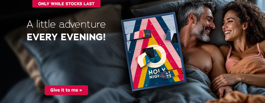 There is a couple on the right-hand side of the advertisement. They are lying together in bed and smiling at each other. The man is topless and the woman is wearing a bra. The Advent calendar in a colourful design and the text “HOLY NIGHTS” are prominently displayed. The sentence: “A little adventure every evening!” can be seen above this in white letters. There is a red banner at the top with the words “Only while stocks last”. There is another red banner at the bottom with the words “Give it to me »”.