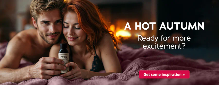 Couple lying closely embraced on a purple duvet, holding a massage oil in their hand; fireplace in the background, text “Hot in autumn – Ready for more excitement??” and button “Get inspired”.