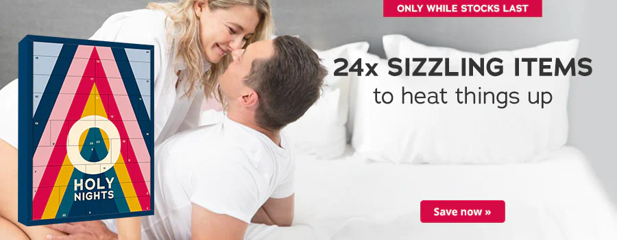 The advertisement has a picture of a man in a white T-shirt lying on a bed. A woman is leaning over him. She is wearing a white blouse. They are smiling at each other. The Advent calendar with a colourful design and the text “HOLY NIGHTS” is prominently displayed. The sentence: “24x sizzling items to heat things up!” is written above in black letters. There is a red banner at the top with the words “Only while stocks last”. There is another red banner at the bottom with the words “Save now »".