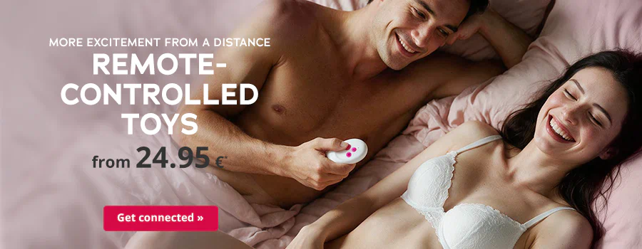 A smiling couple is lying on a pink bed. The man is holding a white remote control in his hand. The text says: “MORE EXCITEMENT FROM A DISTANCE”, “REMOTE-CONTROLLED TOYS” and “from 24.95€”. There is also a red banner with the text “Get connected »”.