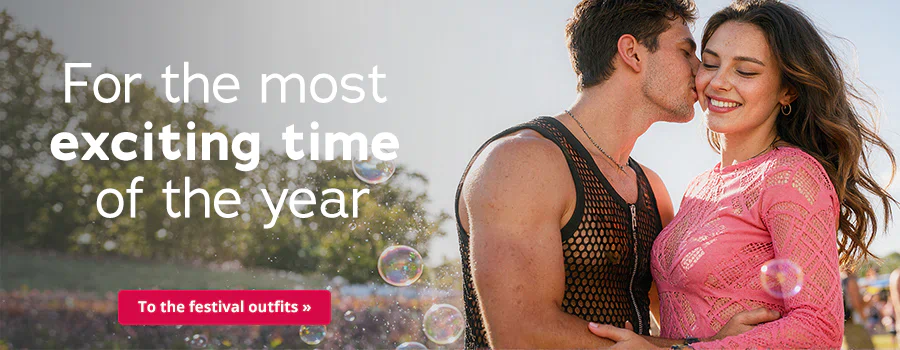 A couple are standing close together outside in the sunshine. The man is kissing the woman on her cheek. She is wearing a long-sleeved pink lace top and he is wearing a black mesh T-shirt. It says: “For the most exciting time of the year” at the top and there is a red button at the bottom that says: “To the festival outfits »”.