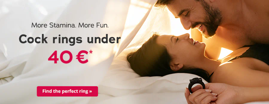 A smiling couple are lying close together in bed, looking at each other. The woman is holding a black cock ring. On the left is the text ‘More stamina. More fun. Cock rings under €40*’ with a red button saying ‘Find the right ring’.