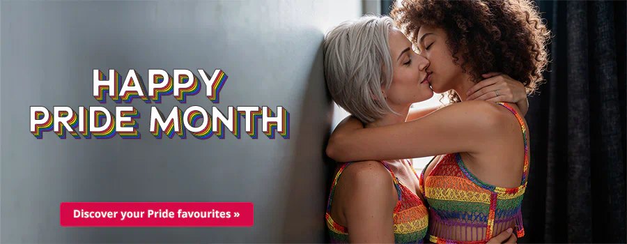 Two women are kissing and holding each other tightly. They are in front of a grey background. One has short silver hair and the other one has curly brown hair. They are wearing rainbow-coloured tops. There is some text at the top that says: “HAPPY PRIDE MONTH”. There is a red button at the bottom that says: “Discover your Pride favourites »”.