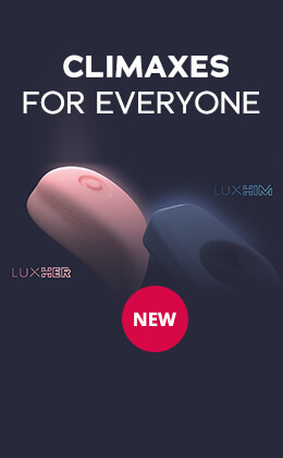 The advertisement shows two hands on a bed. One hand is holding a pink lay-on vibrator with a button, the other hand is holding a blue cock ring. There is a red circle at the top left of the advertisement with the word “NEW” written on it in white letters. On the right-hand side of the advertisement, the words “CLIMAXES FOR EVERYONE” are written in white letters. There is a red banner at the bottom of the advertisement with white text that says: “Order now”.