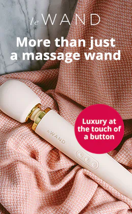 A white massage wand from the le WAND brand is lying on rose-coloured knitted fabric that's against a grey marble background. It says “More than just a massage wand” at the top of the advertisement. It also says “Luxury at the touch of a button” on the right-hand side. There is also a red "Discover now" button at the bottom.
